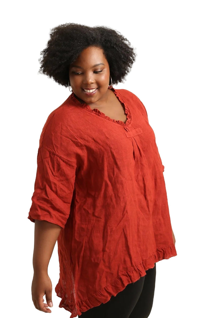 Woman wearing a rust top against a white background