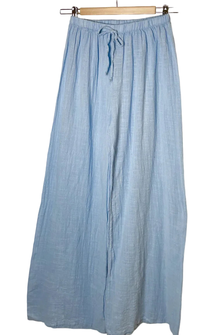 sky blue pants hanging on a rack against a white background