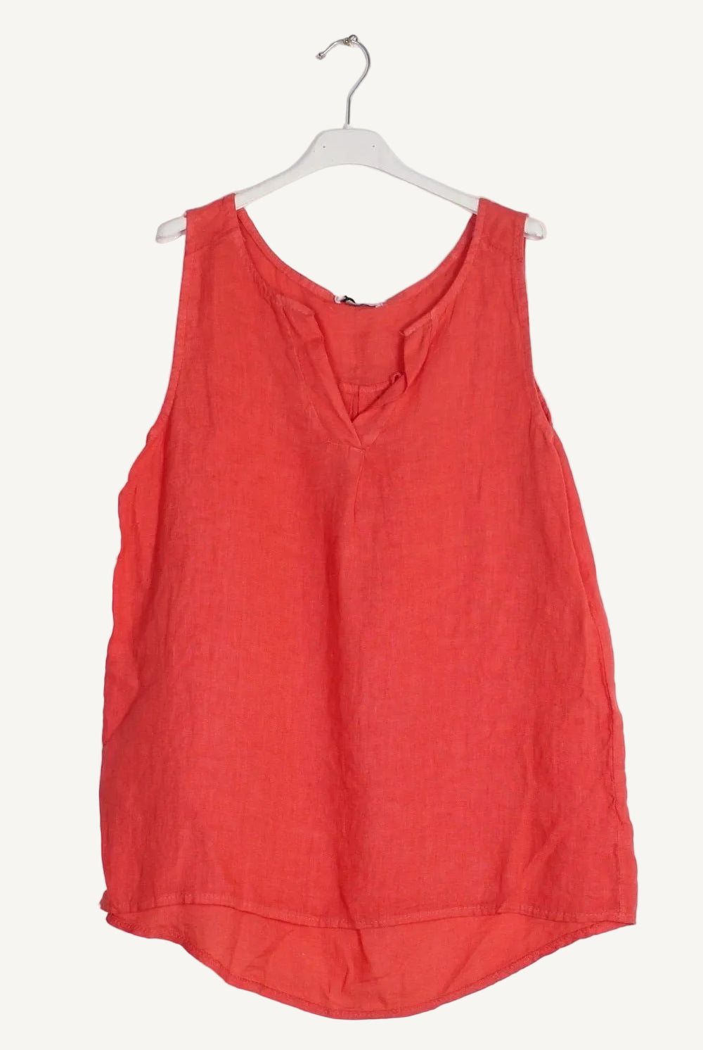 Coral sleeveless top on a white hanger