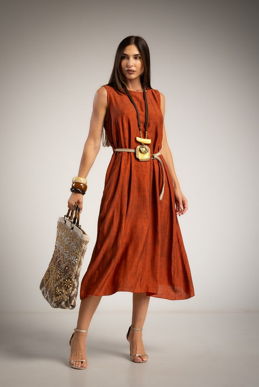 A woman models a sleeveless orange midi dress with a belt