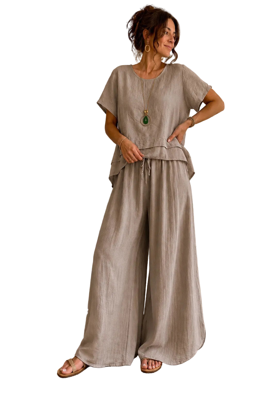 A woman models a two-piece linen set consisting of a short-sleeve top and wide-leg trousers in a light taupe-beige color