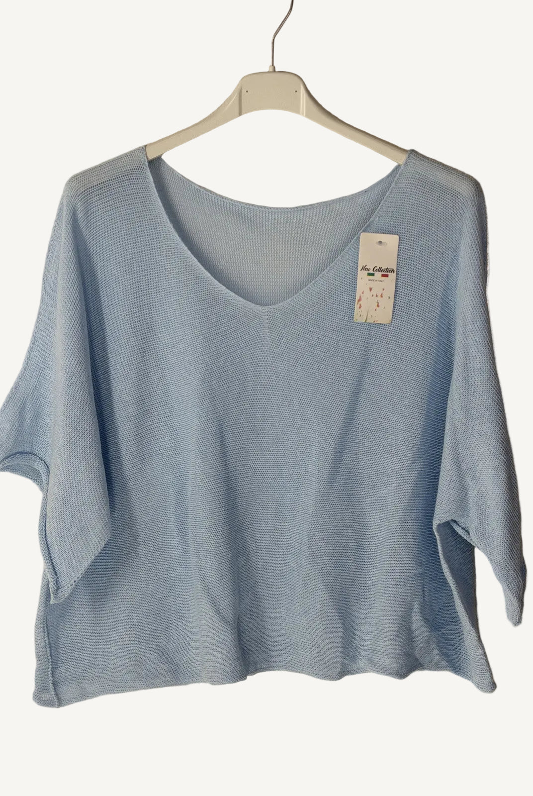 Light blue t-shirt on a hanger with a beige background
