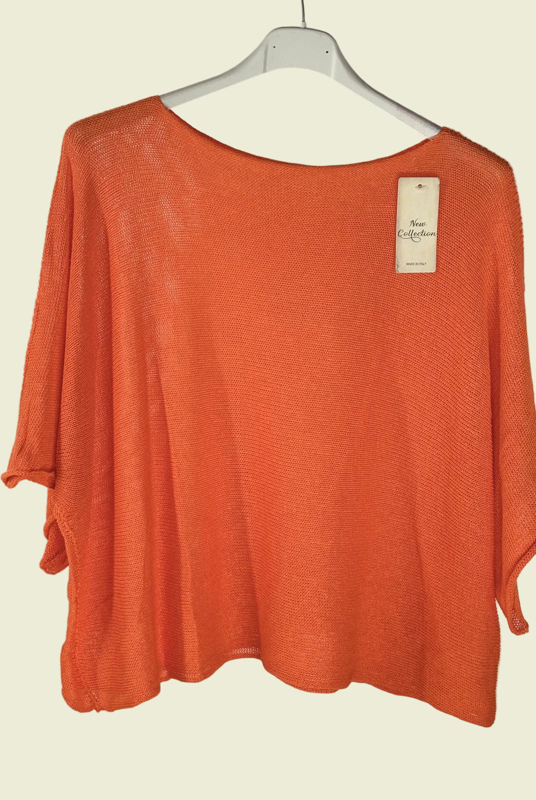 Orange sweater on a hanger