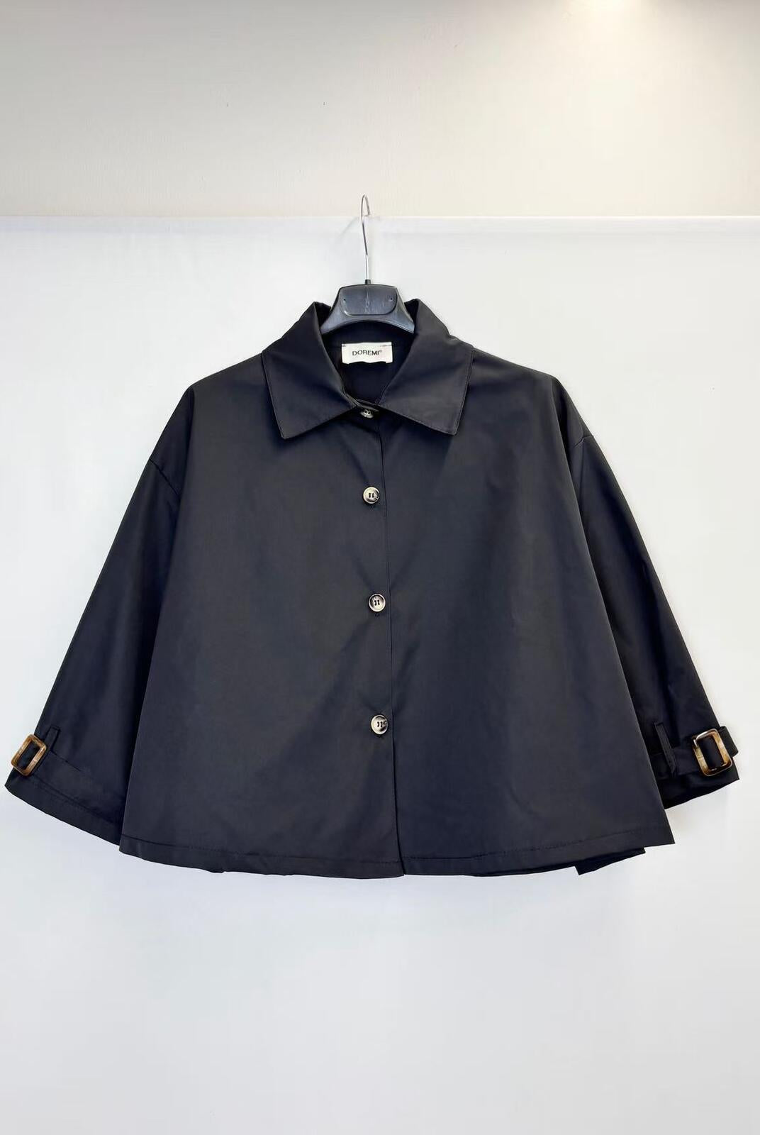 A black cropped long-sleeve collared jacket with button-front closure and adjustable cuff straps,