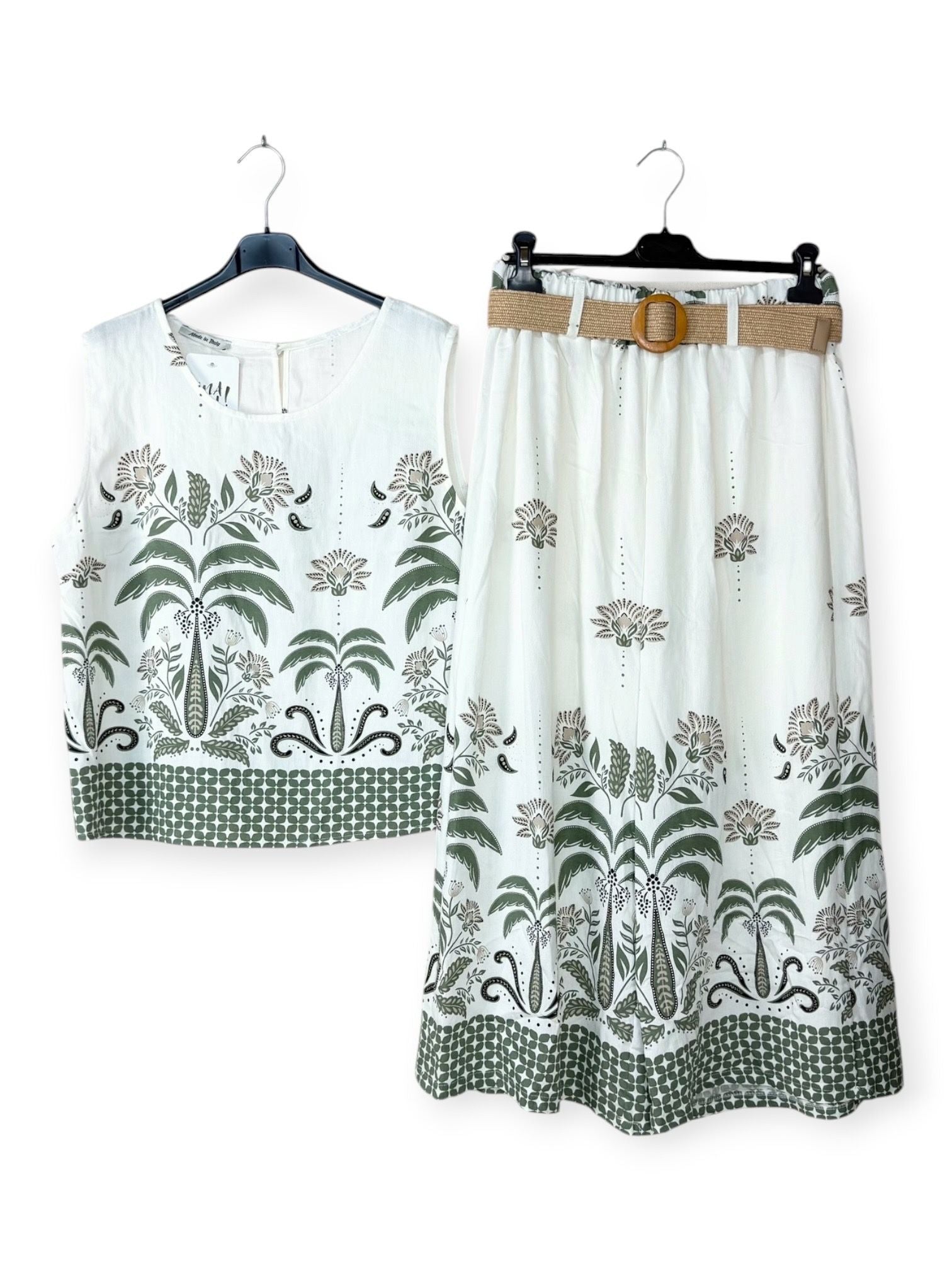 White sleeveless top and trousers with khaki floral patterns on hangers against a white background