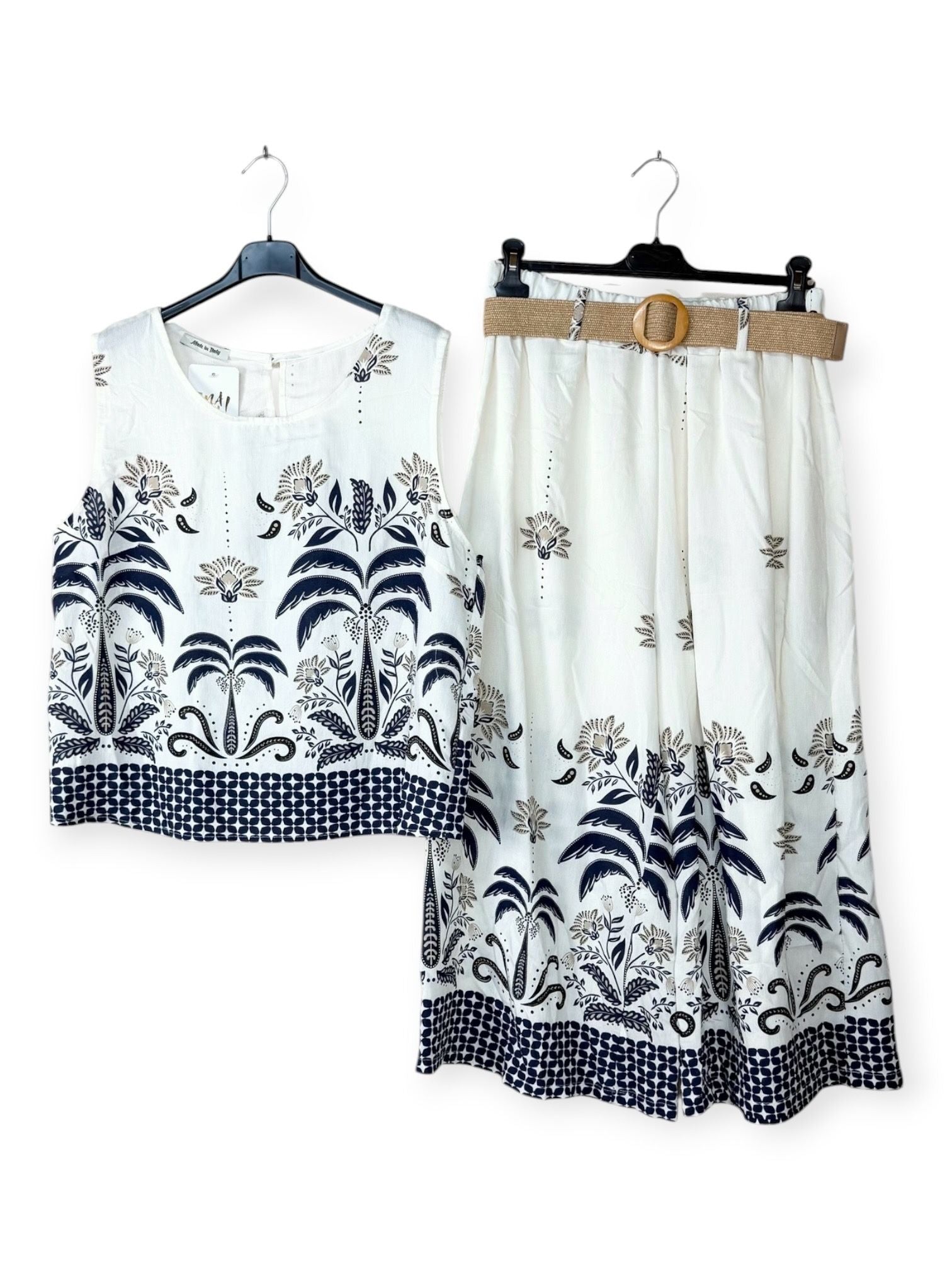 White outfit with navy floral patterns on hangers against a white background
