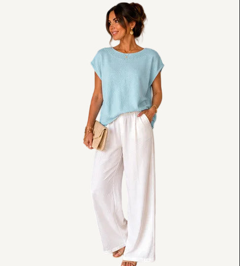 Woman wearing a light blue top and white pants, with product details displayed.