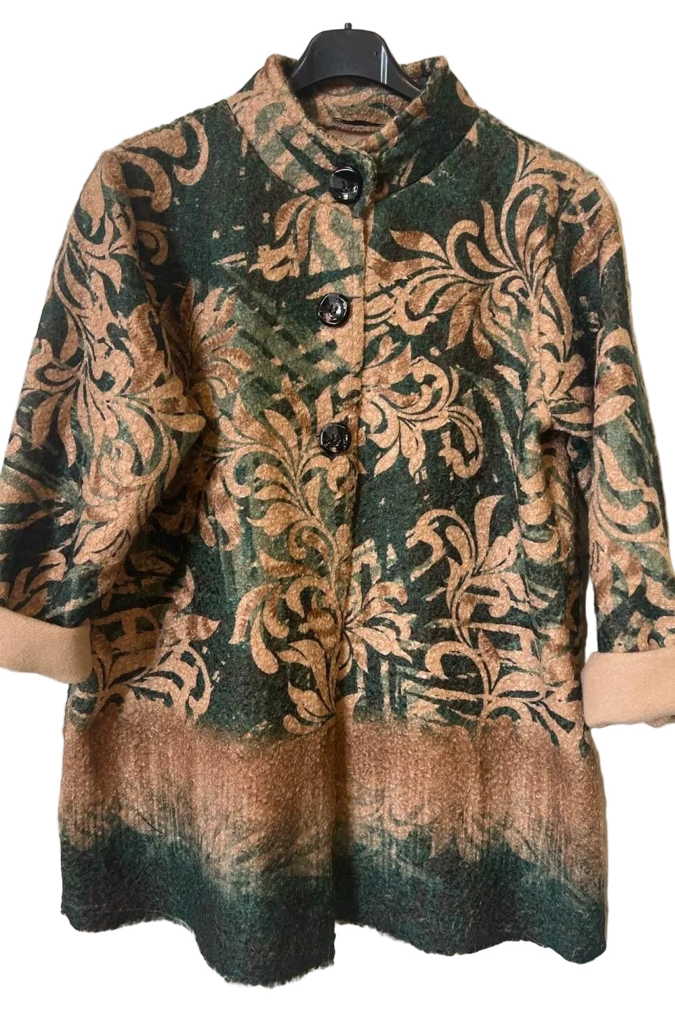 A women's three-quarter sleeve jacket with a mandarin collar, featuring a dark green and brown damask pattern with a gradient fade at the hem, hanging on a black hanger against a textured gray wall.