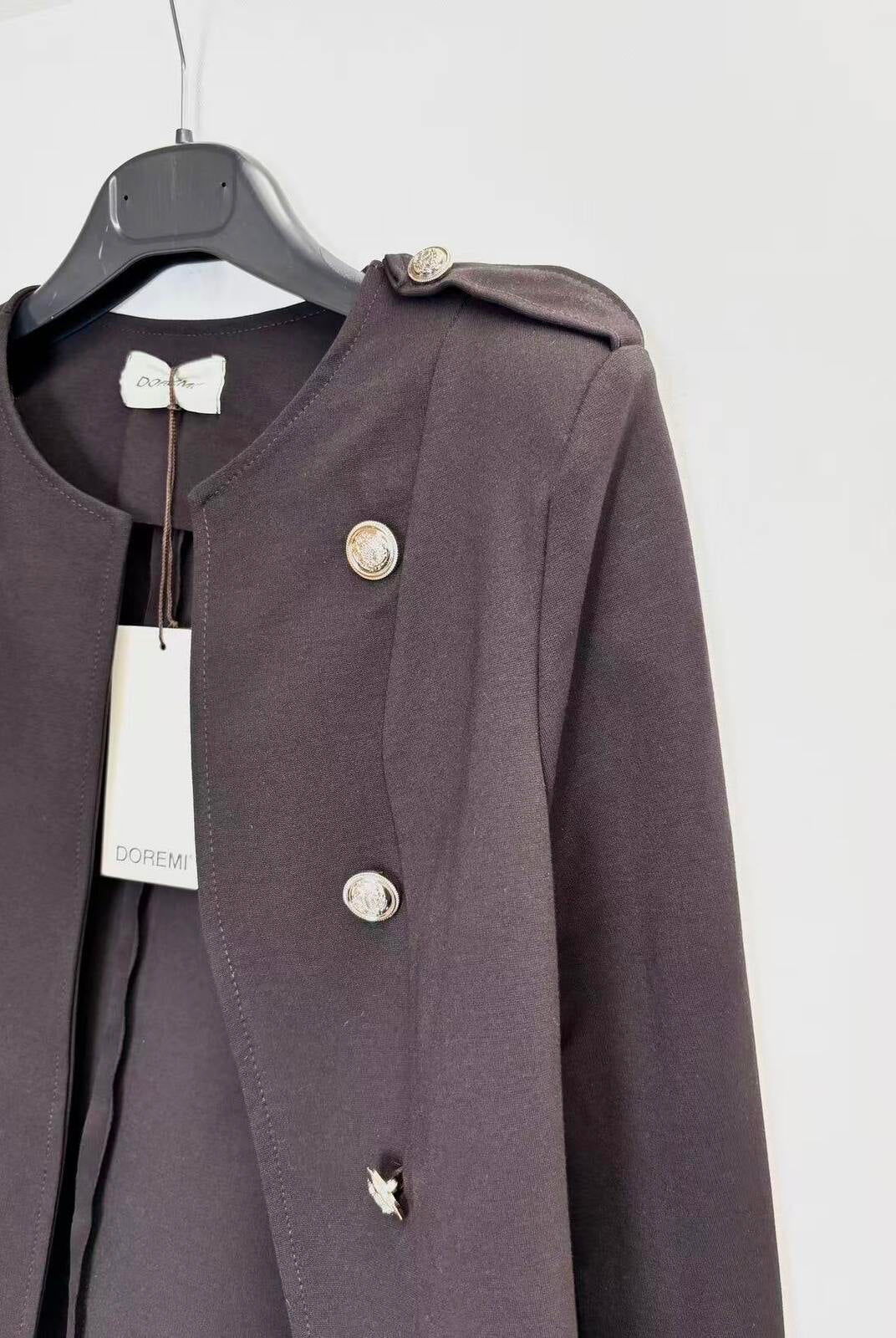 A dark brown double-breasted jacket with silver buttons, hanging on a black hanger with a white brand tag against a plain white background.