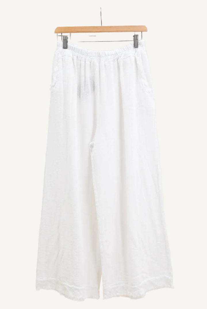 White wide-leg pants on a hanger against a white background