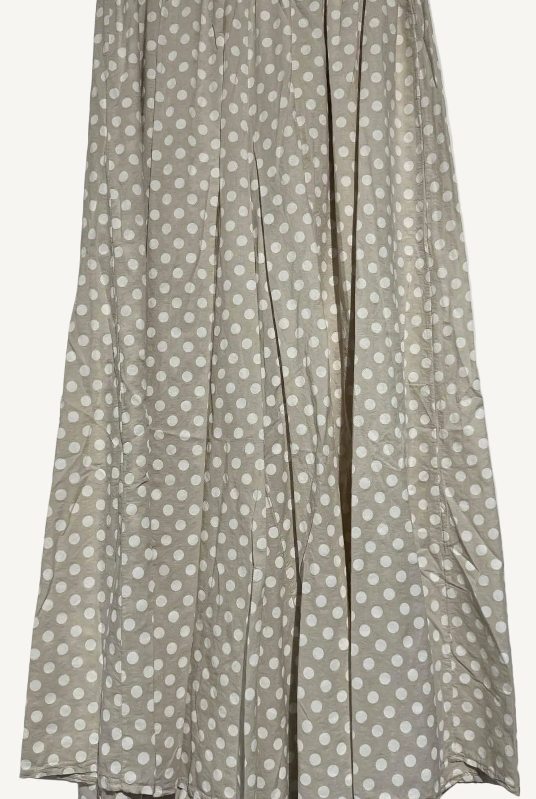 Beige wide leg trousers with white polka dots on a light gray background