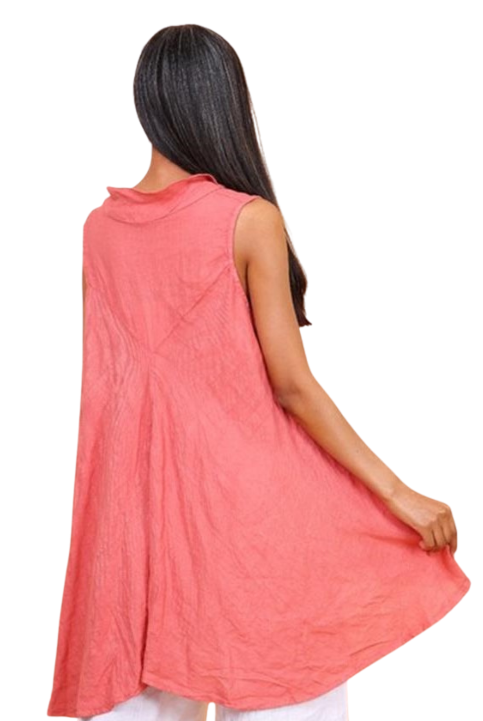 A woman wearing a brick sleeveless cowl neck top with an asymmetrical hem, paired with white trousers.