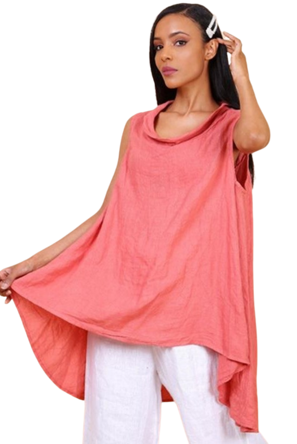 A woman wearing a brick sleeveless cowl neck top with an asymmetrical hem, paired with white trousers.