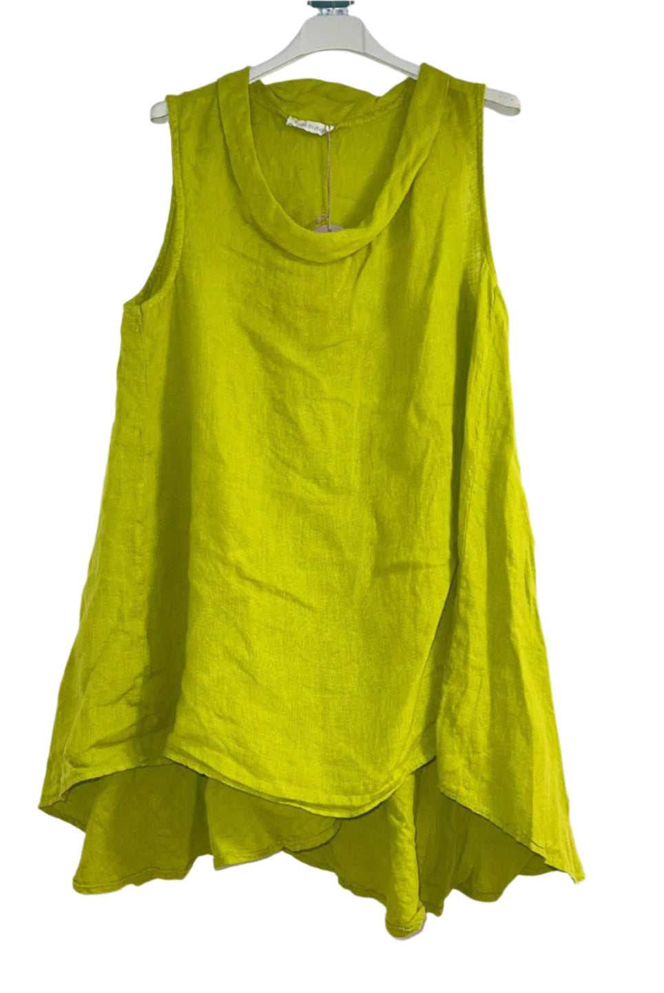 A woman wearing a lime green sleeveless cowl neck top with an asymmetrical hem, paired with white trousers.