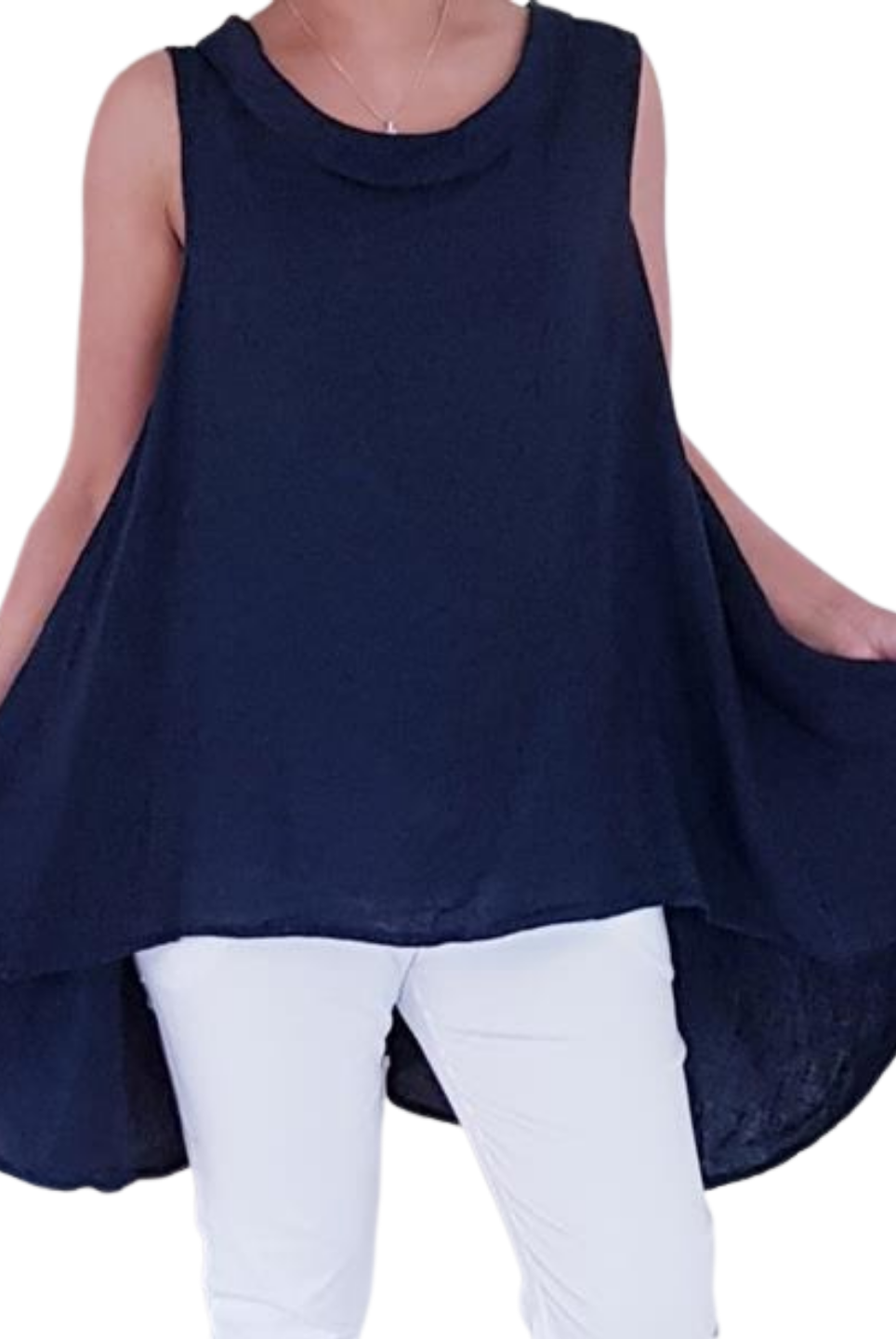 A woman wearing a navy blue sleeveless cowl neck top with an asymmetrical hem, paired with white trousers.