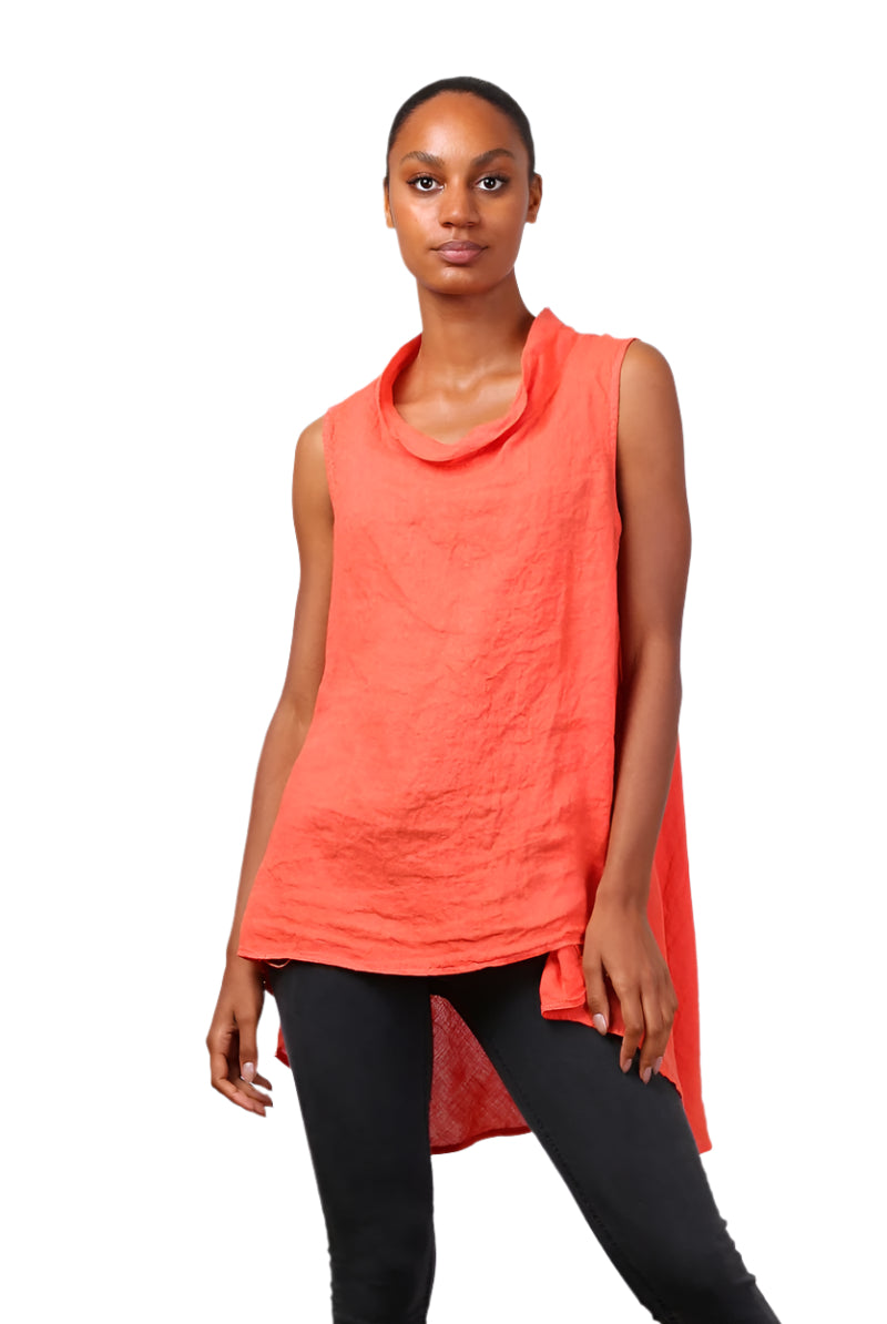 A woman wearing a orange sleeveless cowl neck top with an asymmetrical hem, paired with white trousers.