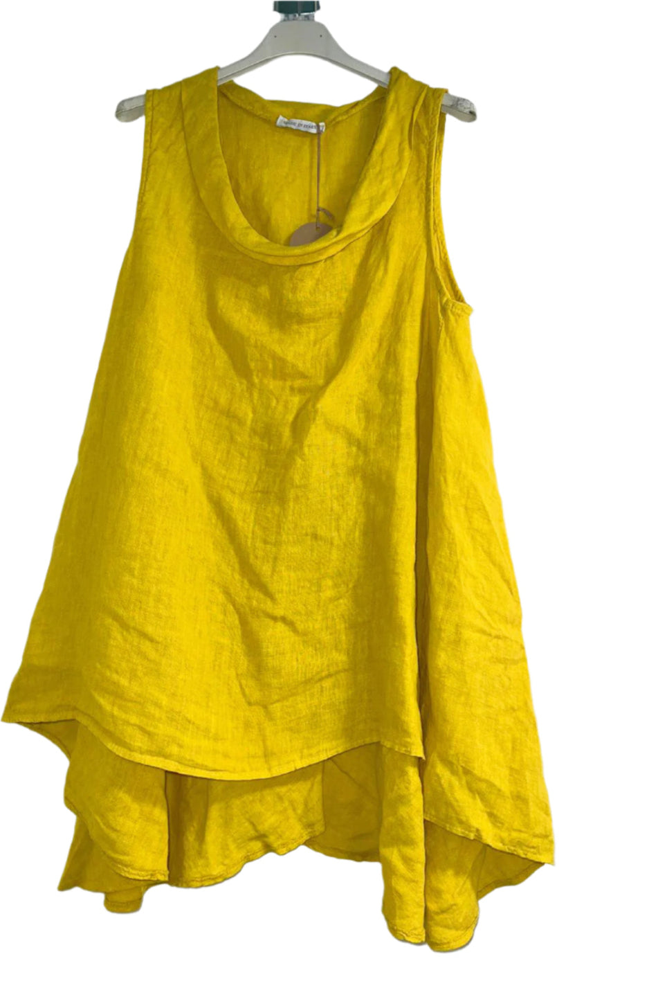 A woman wearing a yellow sleeveless cowl neck top with an asymmetrical hem, paired with white trousers.