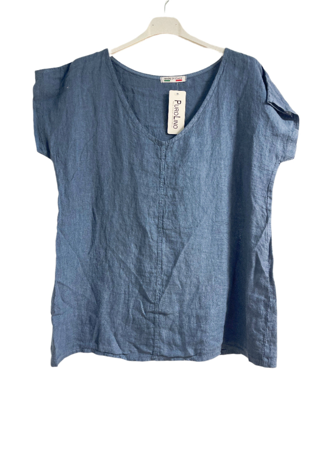 Denlm blue top on a hanger against a white background