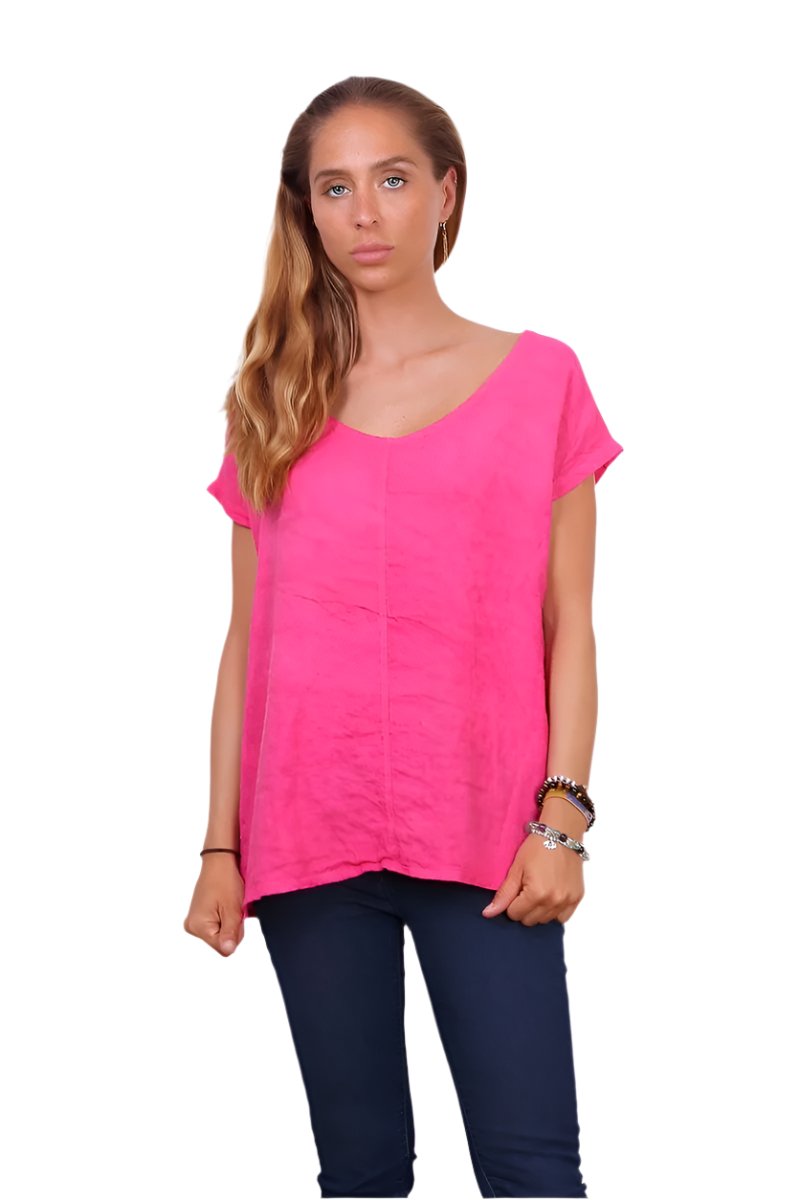 Fuchsia linen top with dark blue jeans against a white background