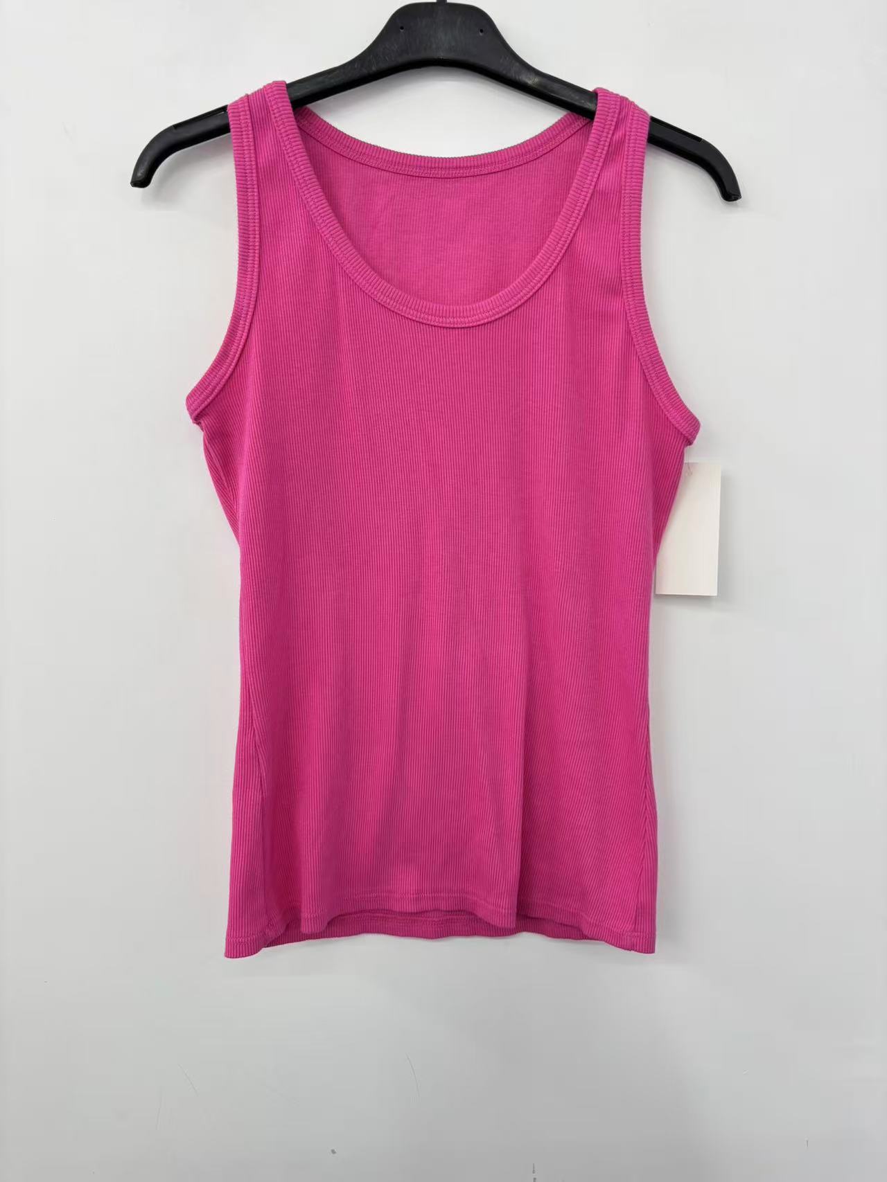 A bright pink sleeveless tank top hanging on a black hanger