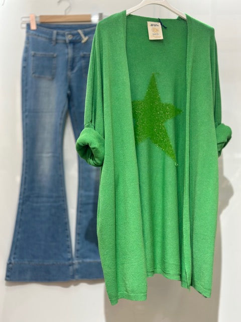 Green cardigan with a star design and blue jeans on a white background