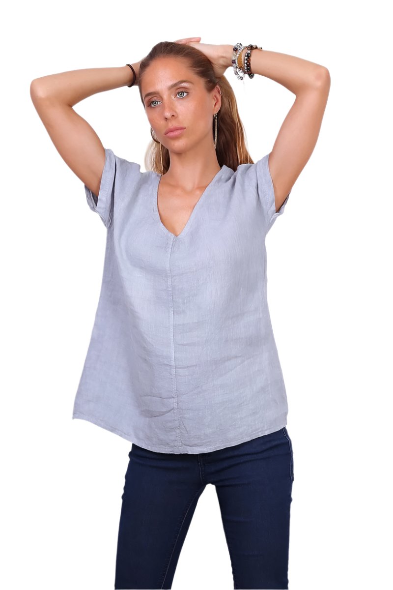 A person wearing a grey v-neck cap sleeve top with a loose fit.