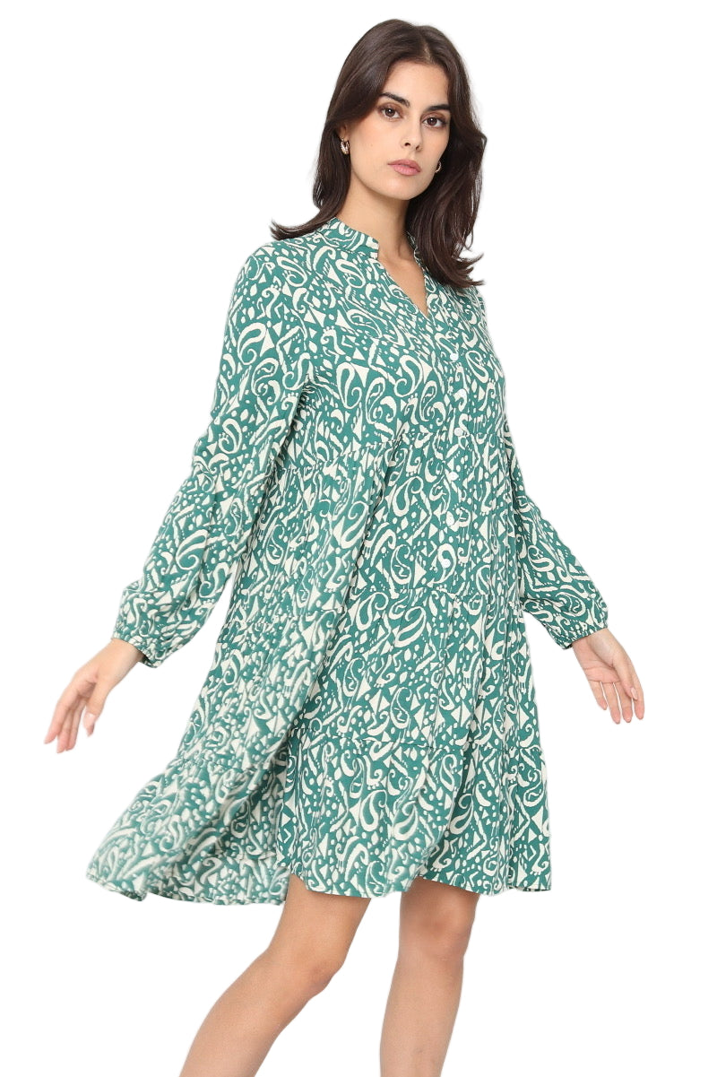 Woman wearing a green patterned dress on a white background
