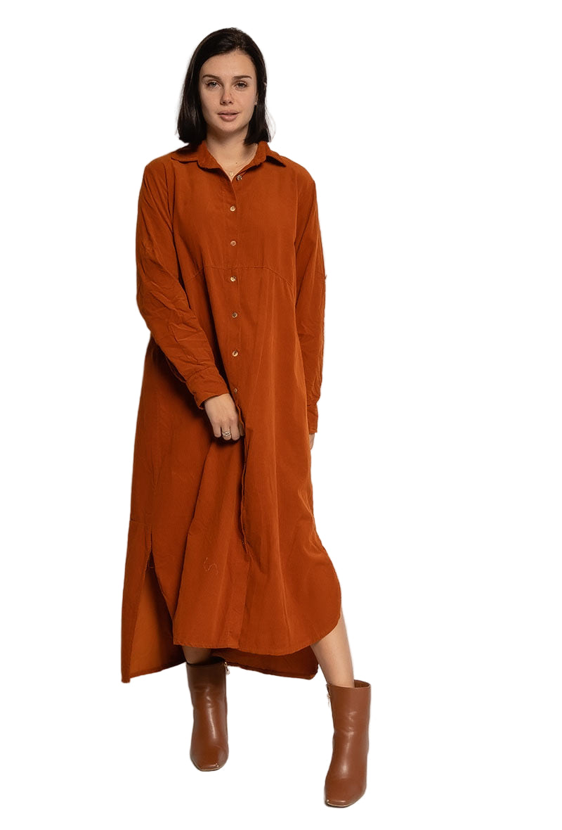 Woman wearing a long rust-colored dress with brown boots on a white background