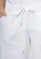 Close-up of white textured pants with a drawstring waist.