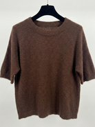 Brown sweater on a hanger against a white background