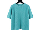 Teal sweater on a hanger against a white background