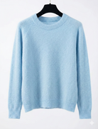 Light blue sweater on a hanger against a white background