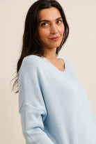 Woman wearing a light blue sweater against a beige background