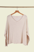 Beige sweater on a wooden hanger 