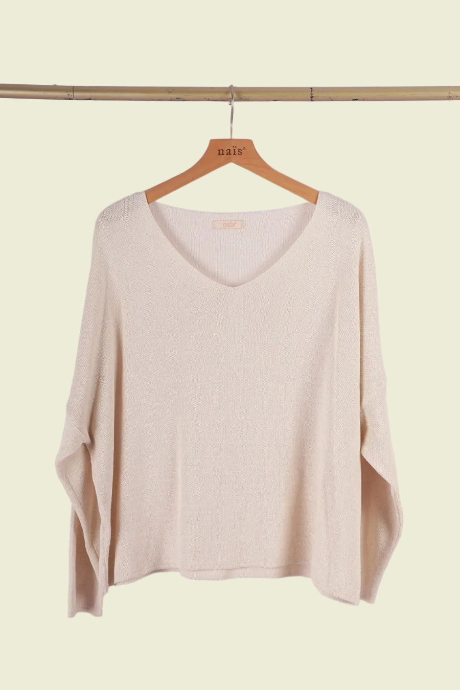 Beige sweater on a wooden hanger 