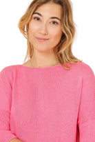 Woman wearing a pink sweater against a beige background