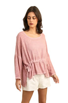Woman wearing a pink top and white shorts on a white background