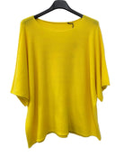 Yellow top on a hanger against a white background
