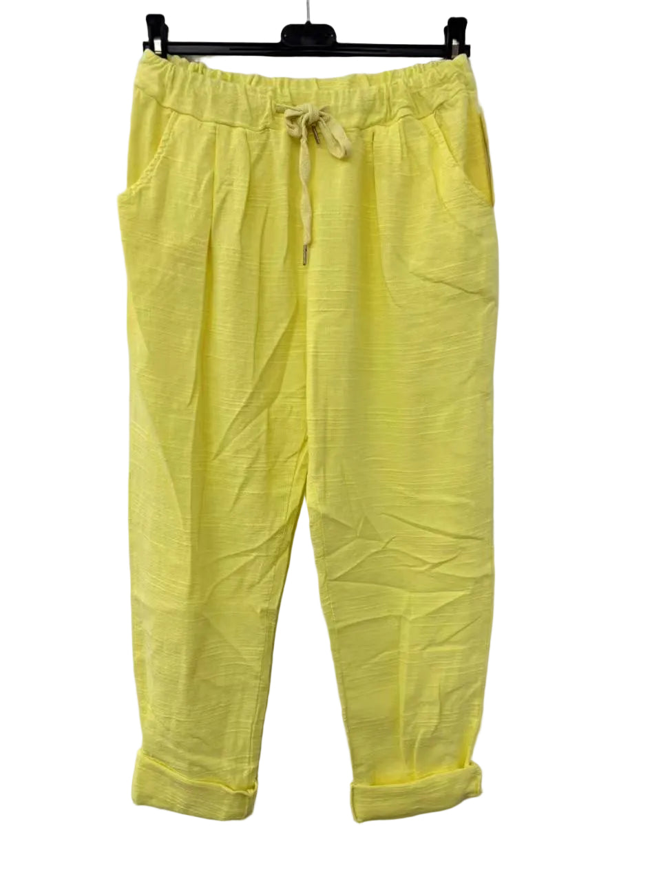 Yellow pants with a drawstring on a hanger against a white background