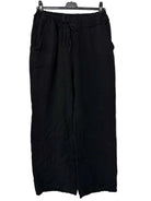 Black pants on a hanger against a white background