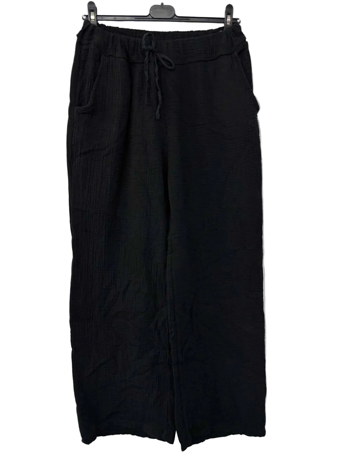 Black pants on a hanger against a white background