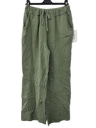 Green cotton gauze pants on a hanger against a white background