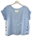 Blue cotton gauze top with button details on a white background