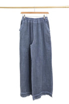 Blue denim wide-leg pants on a hanger against a white background