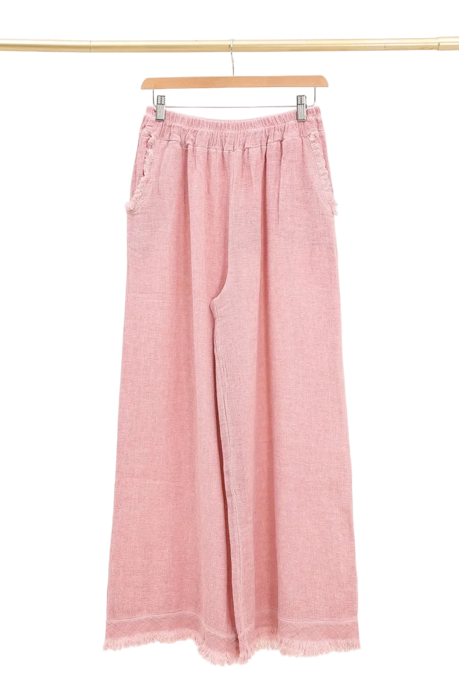 Rose wide-leg pants hanging on a wooden hanger against a white background