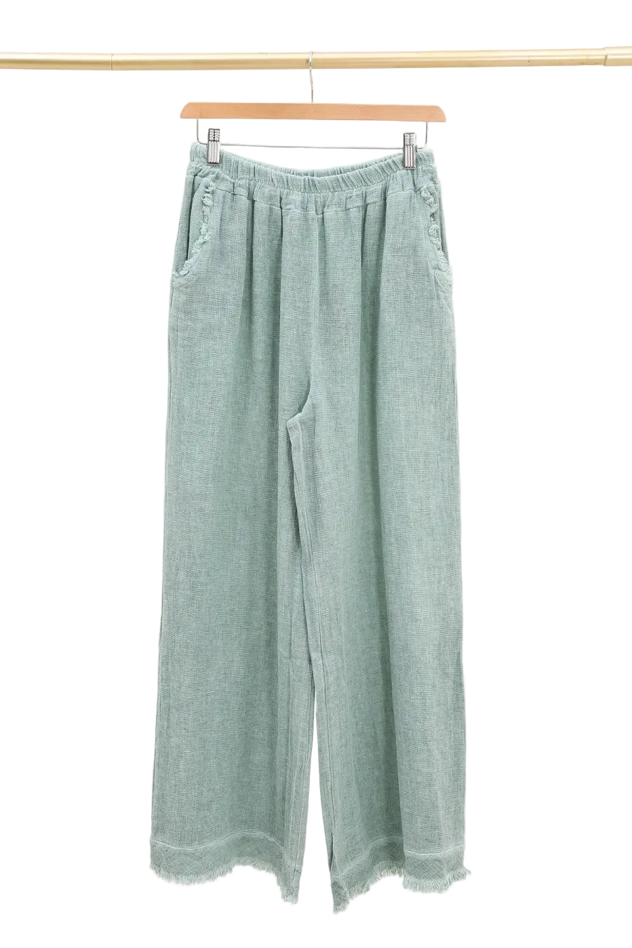 Duck green pants hanging on a wooden hanger against a white background