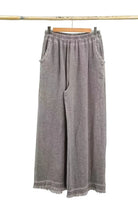 Pair of taupe wide-leg pants on a hanger against a white background