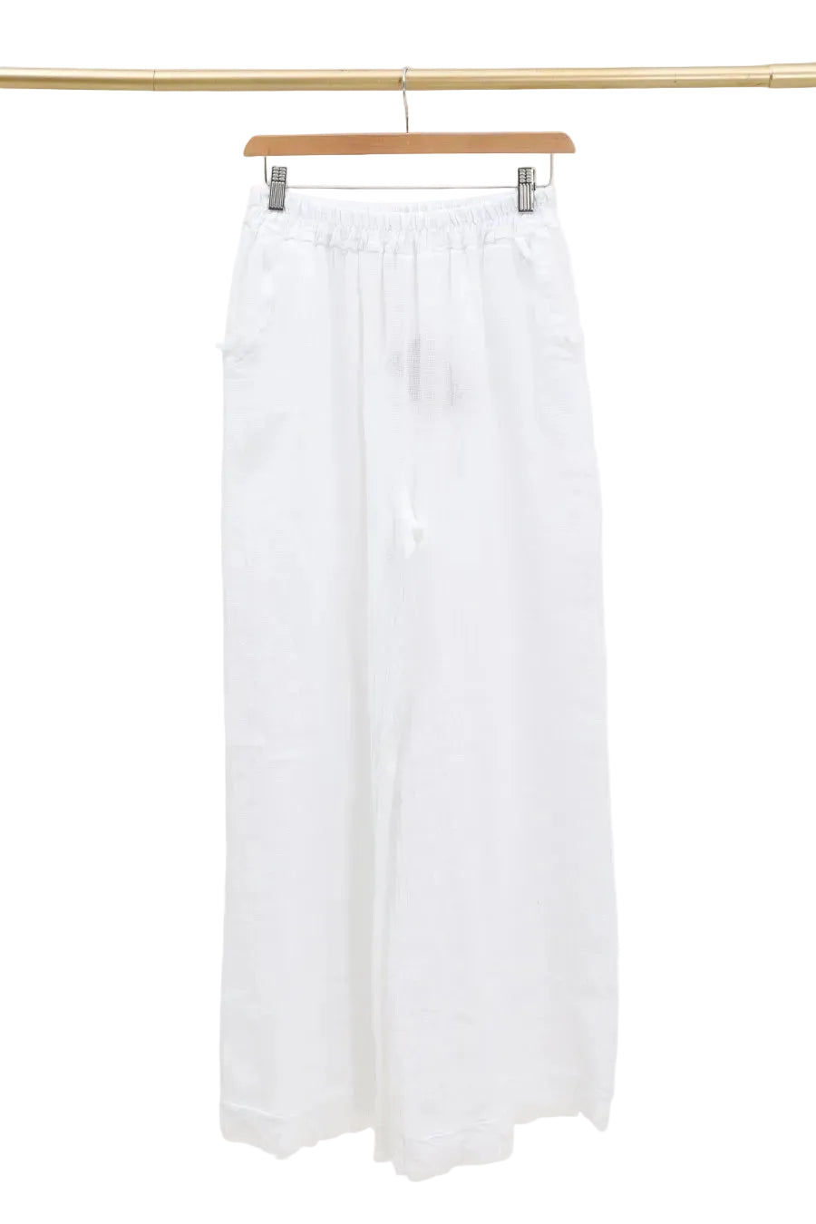White pants hanging on a wooden hanger against a white background