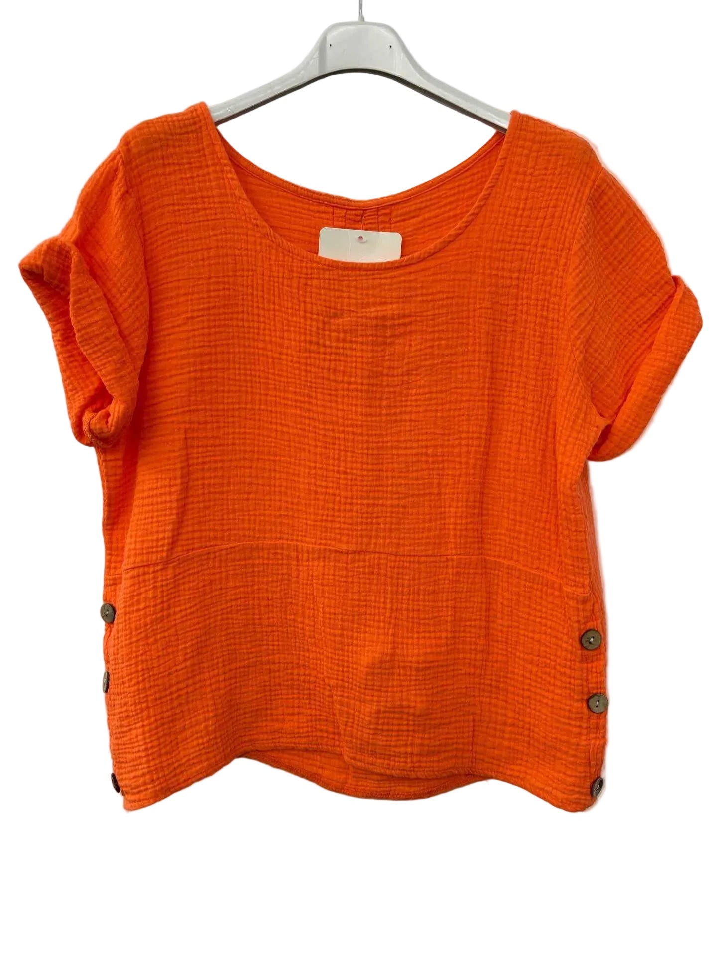 Orange textured top on a hanger against a white background