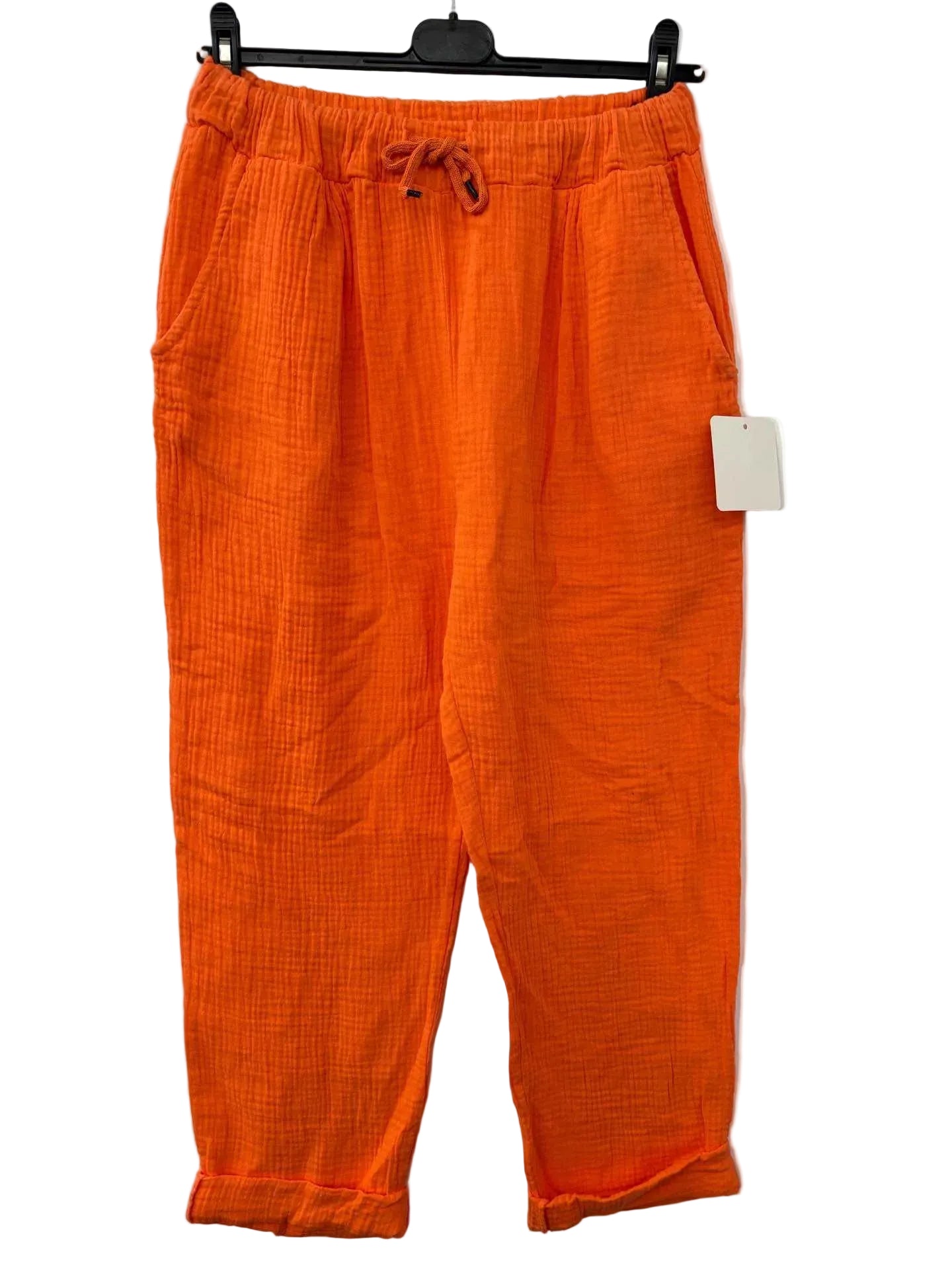 Orange pants with a tag on a white background